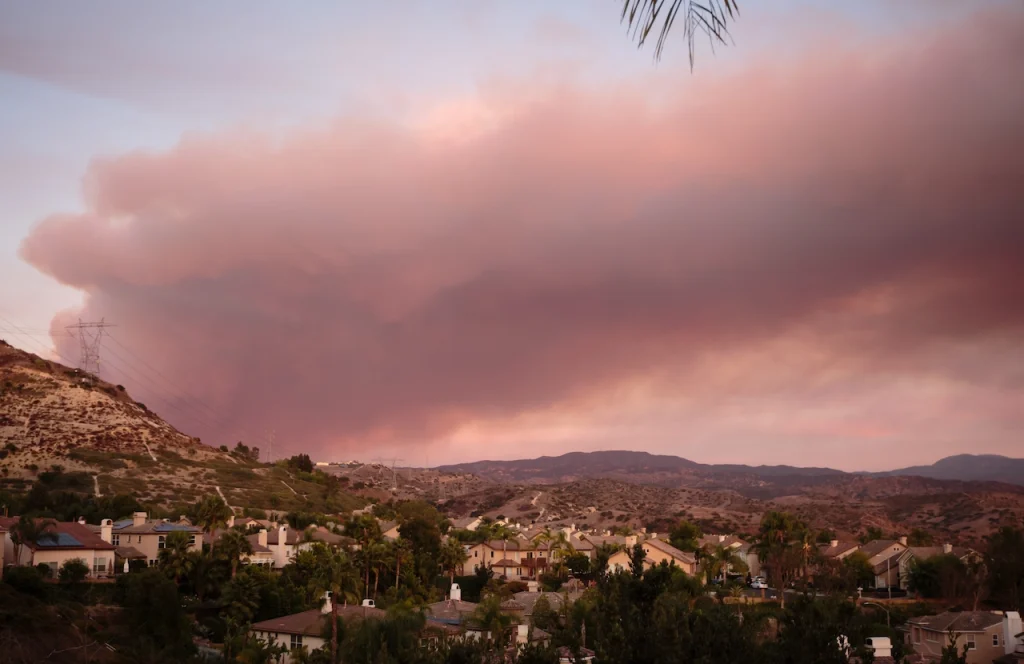 Looming bushfire approaches homes in an Australian neighborhood.